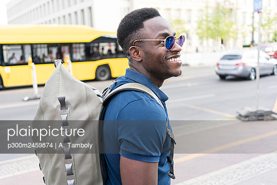 Happy man with backpack walking on footpath - p300m2459874 von A. Tamboly