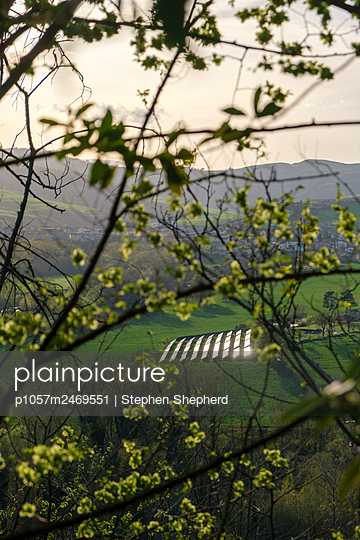 Field with a set of solar panels shining in the sun - p1057m2469551 by Stephen Shepherd