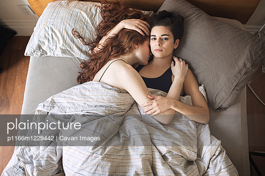 High angle portrait of lesbian with girlfriend relaxing on bed at home - p1166m1229442 by Cavan Images