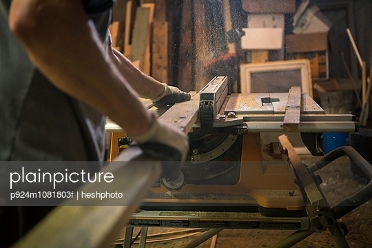 Wood artist in workshop, using woodworking machinery, mid section - p924m1081803f by heshphoto