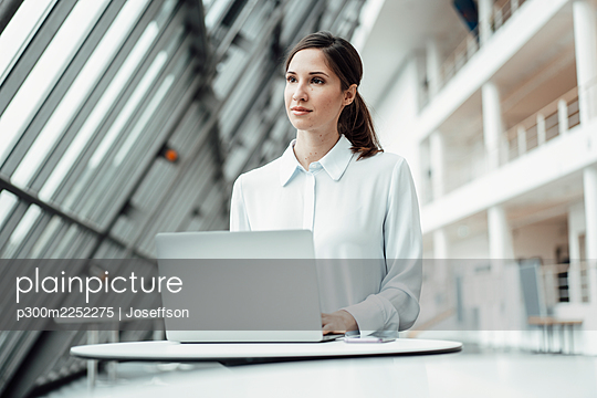 Businesswoman with laptop at desk in office - p300m2252275 by Joseffson