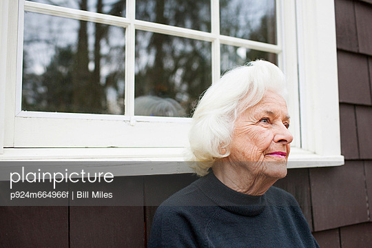 Portrait of senior woman outside house looking away - p924m664966f by Bill Miles